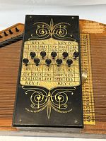 Close view of chord bar assembly showing decorative scrollwork and chord chart