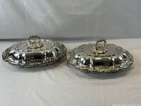 Both silver-plated entree dishes with lids and handles