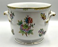 Front view of Herend Queen Victoria cachepot showing floral and butterfly motif and gilt handles