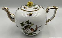 Left side view showing bird motif, butterfly, yellow rose finial, gilt accents