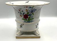 Front view showing floral motif, pedestal base with paw feet