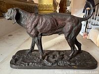Side view of bronze hound sculpture on base