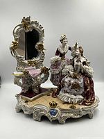 Front view of entire Dresden figurine group showing two ladies, dressing table, mirror and base
