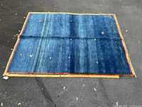 Full view of blue hand-knotted rug showing size and border