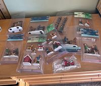 All ten sealed Holiday Living Christmas village packs laid out on table