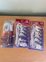 Front view of three packaged Christmas village light cords