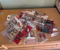 Group view of all sealed Christmas village accessory packs on table