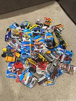 Pile of packaged die-cast vehicles on carpet