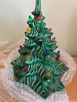 Front view of green ceramic Christmas tree with multicolour peg lights