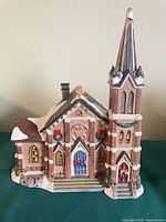Front view of ceramic cathedral with steeple and stained-glass window details