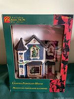 Front of boxed Holiday Collection Lighted Porcelain House