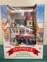 Front view of boxed NOMA Dickensville Collectables porcelain lighted house