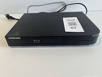 Front view of Samsung BD-H5100 Blu-Ray player showing disc tray and Samsung branding