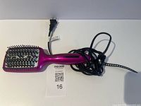 Full view of Infiniti Pro Conair hot brush with cord coiled