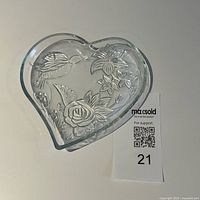 Top view of clear glass heart-shaped dish showing hummingbird and floral embossing