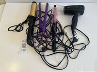 Group shot of four corded hair tools on surface
