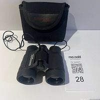Front view of Tasco compact binocular with pouch and lot card