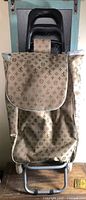 Front view of folding shopping cart with patterned bag and flap