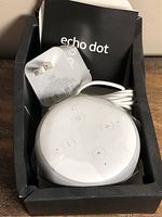 Echo Dot speaker inside damaged box with manual