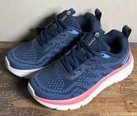 Side view of both shoes showing knit uppers, midsoles, and tags