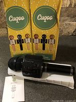Two boxed Cuqoo wireless karaoke microphones with one microphone and manual displayed