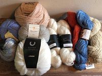 Overview of nine assorted yarns showing colours, labels and fibre types