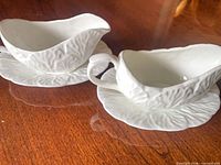 Two creamers on matching saucers