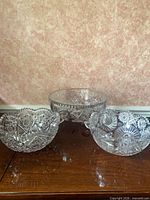 All three cut crystal bowls on wooden surface