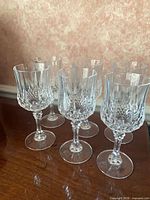 Front view of all six crystal wine glasses on wooden surface