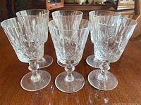 six matching cut crystal wine glasses front view