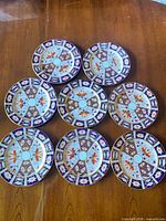 All eight Royal Crown Derby Imari salad plates displayed on tabletop