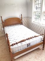 Full view of assembled oak four-poster bed with mattress