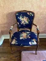 Full front view of carved armchair with floral upholstery