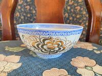 Side view of bone china bowl showing exterior floral motif and blue rim border