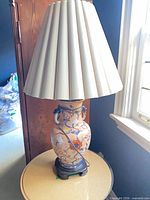 Full view of lamp with pleated shade on round table