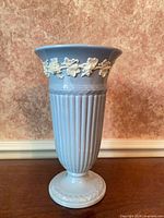 Full view of blue Wedgwood vase showing ribbed body and footed base