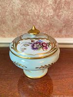 Front view of Limoges covered pedestal dish showing pedestal base, floral design, gold accents