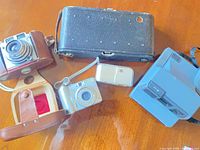 Group shot of all five cameras and cases on table