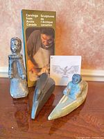Group shot of three soapstone carvings plus brochure