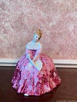 Front view of Victoria figurine showing gown, fan and height perspective