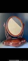 front view of oval mirror on carved stand