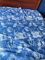 Overall view of blue and white toile duvet cover and shams on bed