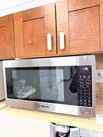 Front view of Bosch stainless microwave on shelf