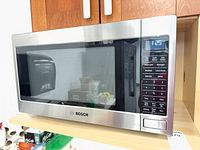 Front view of Bosch stainless steel countertop microwave on shelf