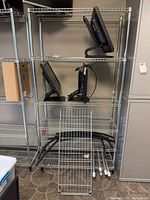 Full view of assembled chrome wire shelving unit with extra shelf panel and posts in front
