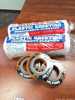 Lot overview showing 3 Gorilla Tape rolls and 2 Weather-All plastic sheeting rolls