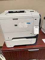 Front and left side view of HP LaserJet P3015 with two paper trays