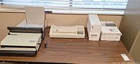 Laminator, comb binding machine, three supply boxes on tabletop