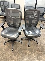Front view of both mesh-back chairs showing seats, armrests and bases
