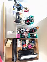 Overhead view of four bins containing assorted office supplies